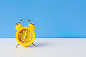 Alarm yellow vintage alarm clock falling on the floor with blue color background, copy space for...