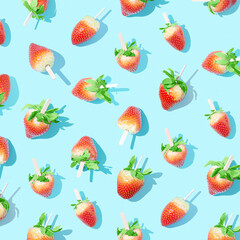 Juicy strawberries on a stick on a bright blue background with sharp shadows.