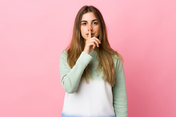 Young woman over isolated pink background showing a sign of silence gesture putting finger in mouth