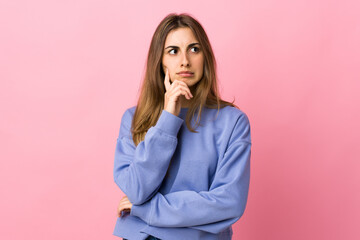 Young woman over isolated pink background having doubts and thinking