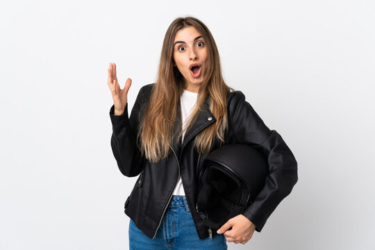 Young Woman holding a motorcycle helmet over isolated white background with surprise facial expression