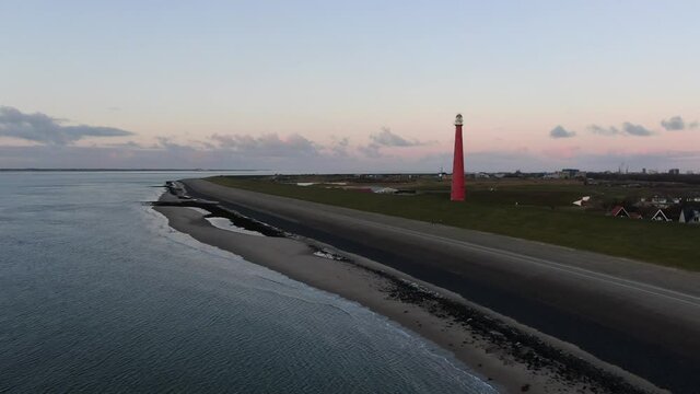 4k dynamic aerial video of red lighthouse at the Dutch town of Den Helder