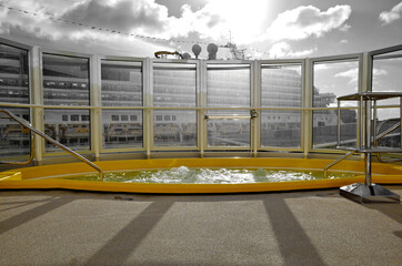 Outdoor pool deck with sun loungers and deck chairs on modern cruiseship or cruise ship liner