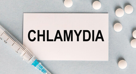 On the card text CHLAMYDIA, next to a syringe and white tablets.