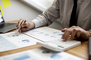Businessman working in a private office, he is reviewing the company's financial documents sent from the finance department before he takes it to a meeting with a business partner. Financial concept.