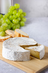 Camembert with green grapes and wine bottle. Appetizer selection.
