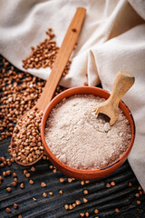 fresh natural buckwheat flour on a dark wooden rustic background culinary concept