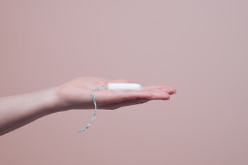 Clean cotton tampon on open female hand. Women hygiene and health concept