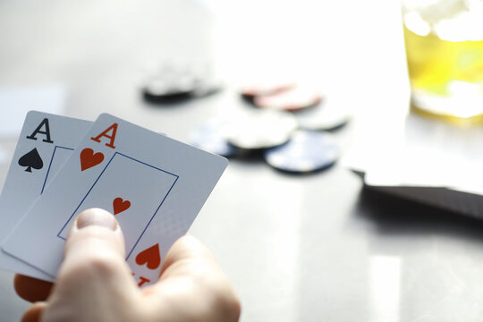 Gambling Card games for money. Texas Hold'em Poker. Cards in hand, playing chips, a deck of cards of alcohol in a glass.