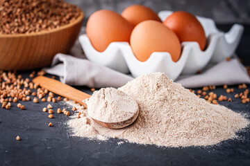 fresh natural buckwheat flour on a dark stone background culinary concept