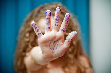 Girl showing hand with drawings of people