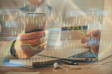 Double exposure of man hands holding a credit card and Forex graph drawing. Stock trading and digital fintech in Internet E-commerce concept.