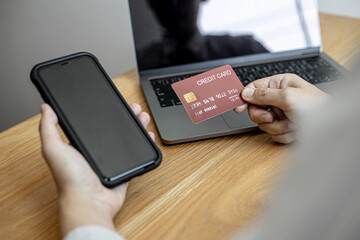 A man holding a smartphone and a credit card, he is doing online shopping through a smartphone app by paying credit card payments. Online shopping ideas with a credit card.
