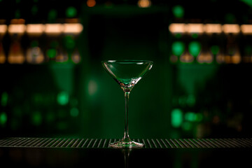 Gorgeous view of martini glass standing on bar counter on blurred background