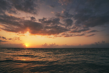 Naklejka premium beautiful golden sunset on the beach over the sea with some dreamy clouds