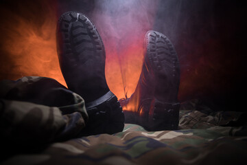 War concept. Old military shoe in a dark toned foggy background. Creative concept of conflict...