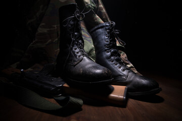 War concept. Old military shoe in a dark toned foggy background. Creative concept of conflict between countries, military aggression.