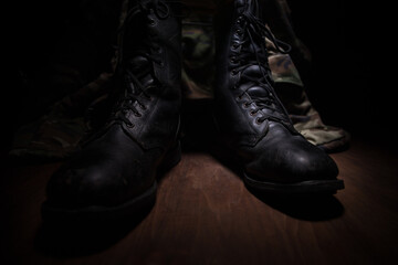 War concept. Old military shoe in a dark toned foggy background. Creative concept of conflict between countries, military aggression.