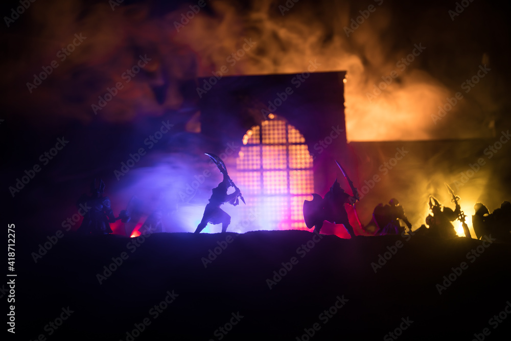 Wall mural Medieval battle scene with cavalry and infantry. Silhouettes of figures as separate objects, fight between warriors on sunset foggy background.