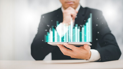 Businessman holding tablet bar graph of analytics and financial, Changes in new planning, Business growth, ideas and perspectives, Stock investment, and dividends yield from business in the new year
