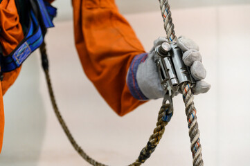 Gloves gripping the rescue rope brake.