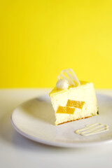 Mousse cake on a white plate on a yellow background