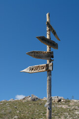 Wooden signpost for tourists in area of Aya bay in Tazheranskaya steppe. Arrows on a sign post pointing the way from the plateau Ulan-Zaba (Baikal Lake, Siberia, Russia)
