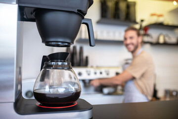 Coffee maker with glass jug of coffee on counter