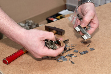 Fototapeta premium Hands hold a metal mebelb fuonitur, close up