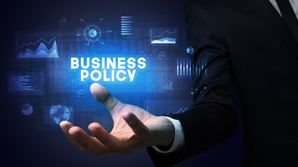 Hand of Businessman holding BUSINESS POLICY inscription, business success concept