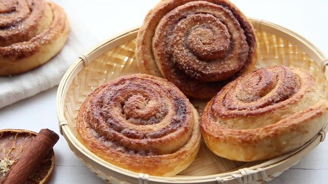 Close up pan of freshly baked homemade cinnamon rolls in basket in the morning indoors, breakfast concept.