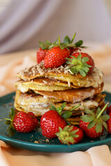 homemade pancakes with strawberries and honey on the table