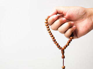 Selective focus close up image  hand of muslim woman holding a prayer beads isolated on white background with copy space. 