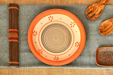 culinary theme composition in natural ethnic style made up table top with a ethnic dish, cotton towel and some useful olive wooden kitchen tools 