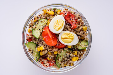 bowl of healthy quinoa with vegetables on a white background