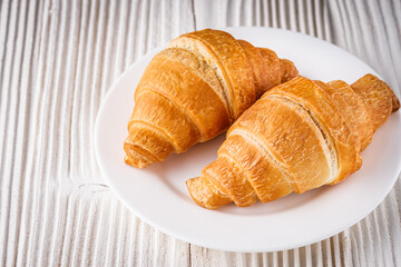 delicious fresh croissant on a white wooden rustic background