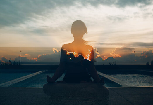 Multiple exposure image of Clouds and sunset. Pranayama in lotus asana woman - Powered by Adobe
