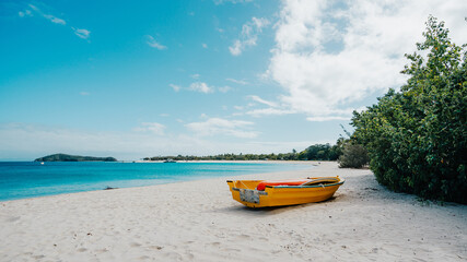 The yellow boat on beach with blue sunny sky and clear ocean located in Great Keppel Island, Queensland, Australia