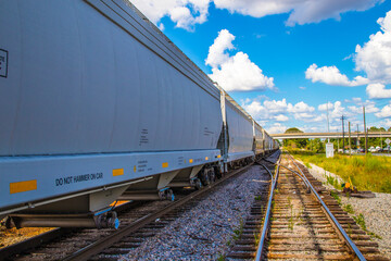 Obraz premium A long train and train track with blue sky and clouds background