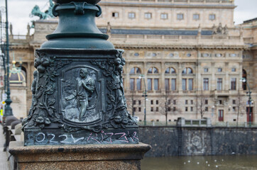 Fototapeta premium Detail of a historical lamp on Legion Bridge with National Theatre behind it, Prague, Czech Republic