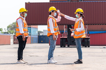 Factory workers wear face mask and safety dress measure temperature before start working stand on queue at outdoor warehouse - safety and health  protect coronavirus protocol concept
