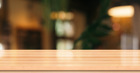 Empty wooden table top with lights bokeh on blur restaurant background.