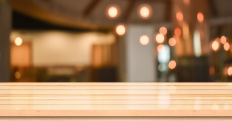 Empty wooden table top with lights bokeh on blur restaurant background.