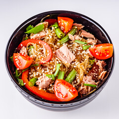 delicious glass noodles with tuna and vegetables on a white acrylic background