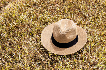 straw hat on the grass, yellow and brown background
