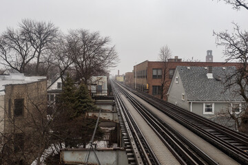 Fototapeta na wymiar Vintage elevated subway tracks cutting through urban neighborhood on overcast day in Chicago