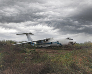 An abandoned old Soviet cargo plane lying on the ground in cloudy weather