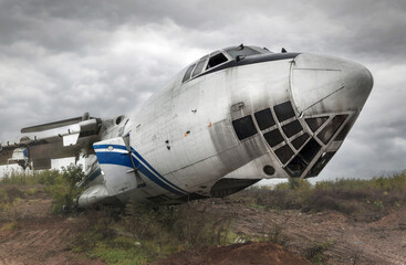 Abandoned old Soviet cargo plane on the ground in cloudy weather. Cockpit close-up