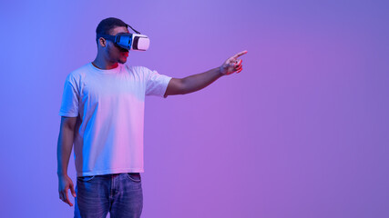 Young Black Man In VR Headset Touching Air While Playing Video Game © Prostock-studio