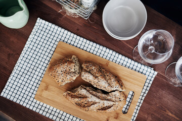 sliced rye bread on a wooden board on a checkered napkin on a wooden table top view